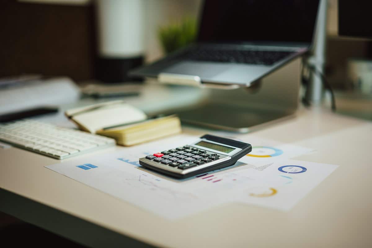 Calculator and tax papers used to check whether taper relief applies to a capital gains tax bill